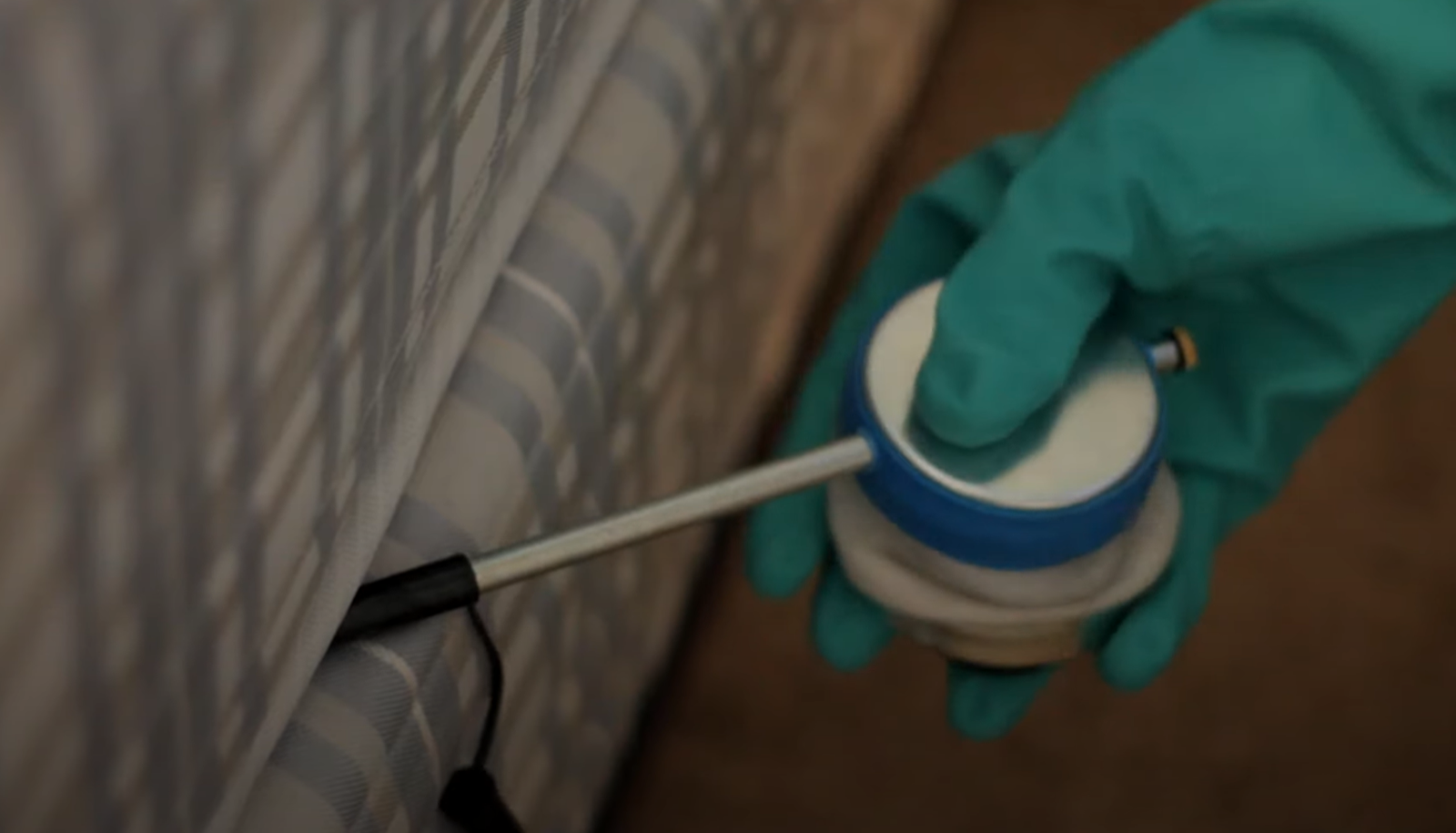 Gloved hand applying pest control solution to mattress seams, representing Pest Control Service in Cicero targeting bedbugs.